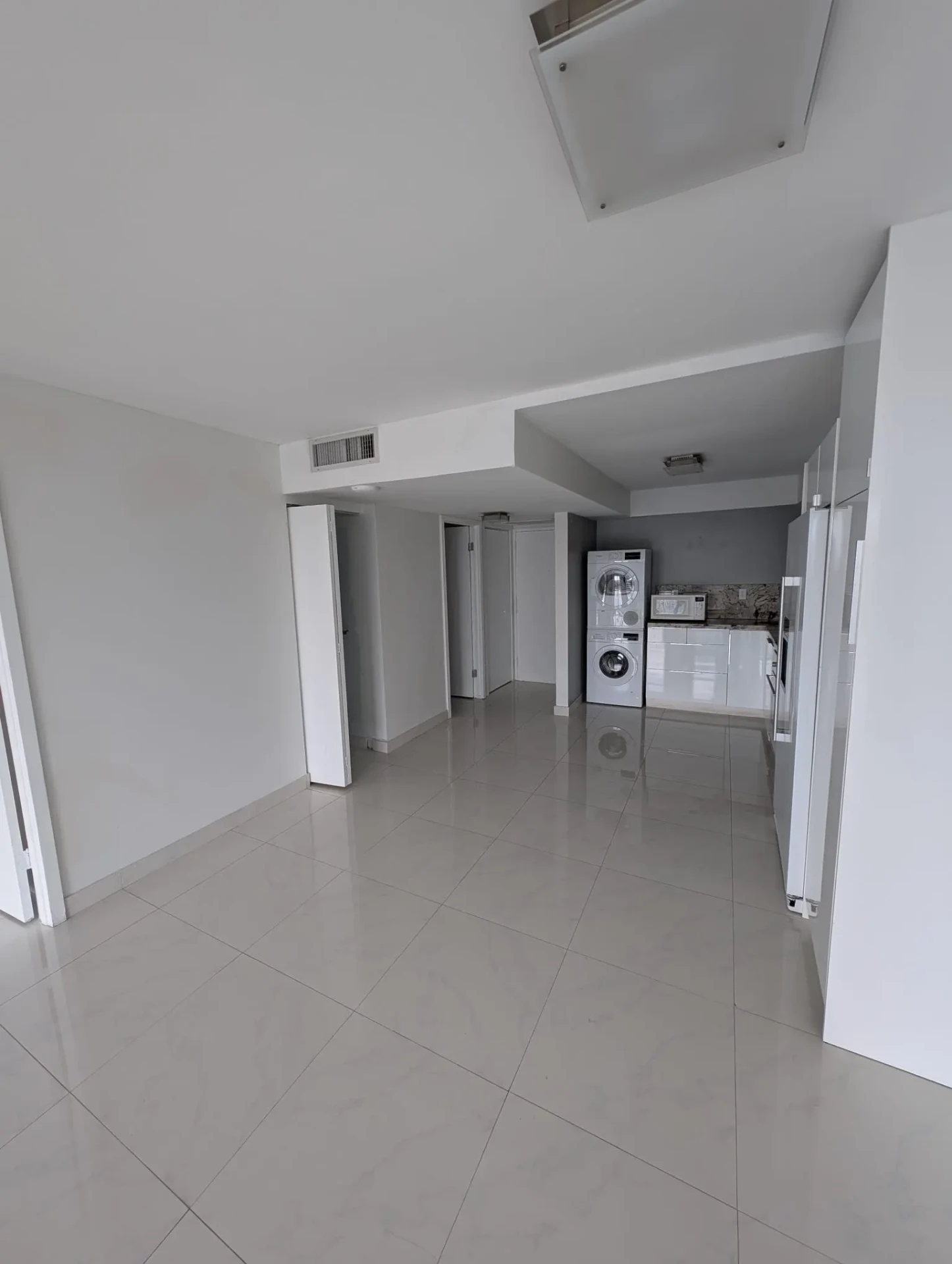 Remodeled interior showing kitchen, tile floor and laundry area