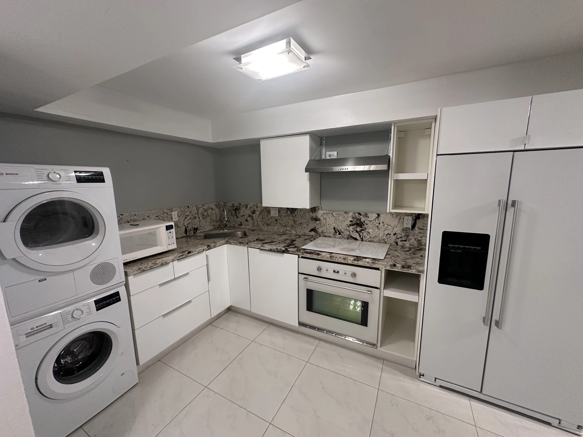 Kitchen remodel with granite counters, wall oven and stacked laundry