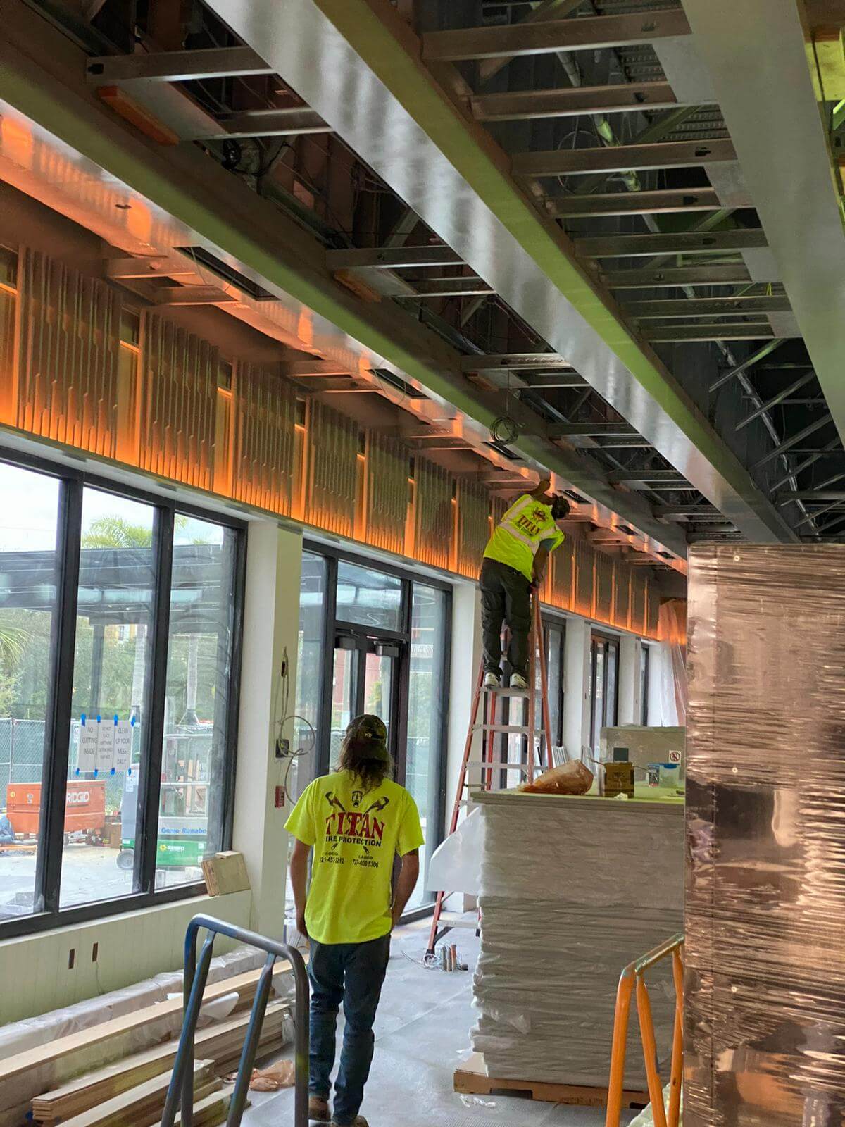 Crew installing ceiling framing and lighting in a restaurant