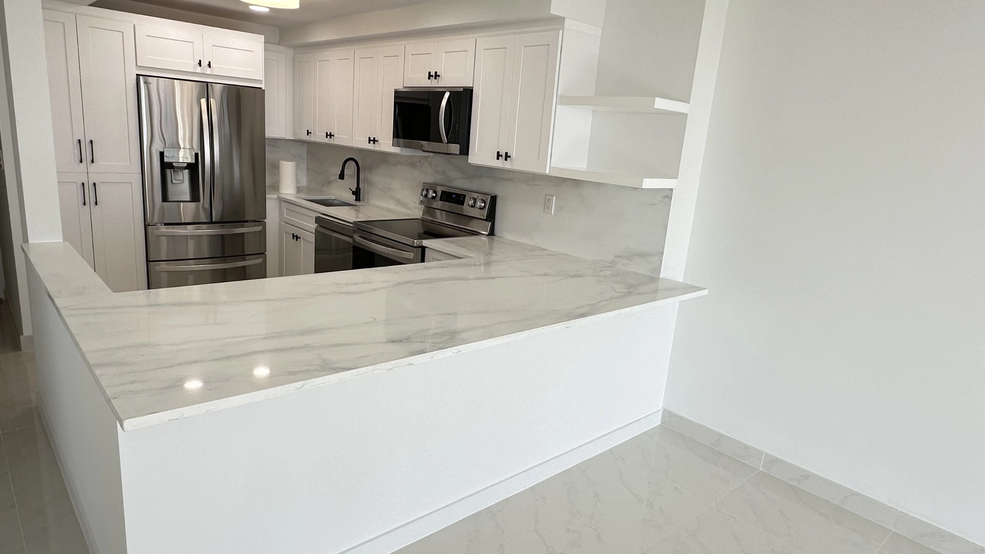 Finished kitchen with stone peninsula and shaker cabinets